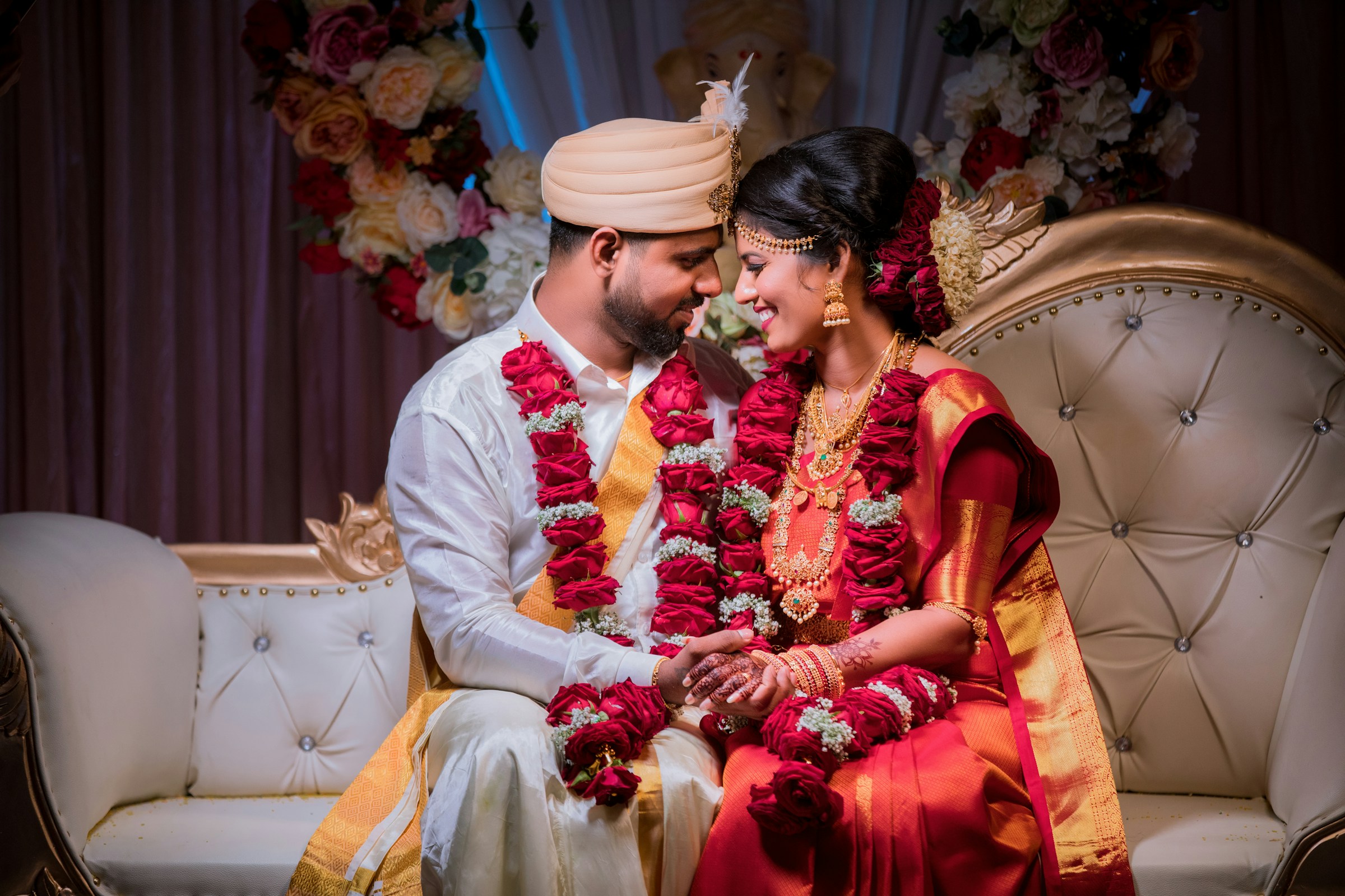 Anjali and Kevin in rose garlands on their wedding day